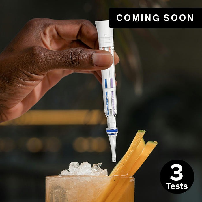 Hand holding 3-in-1 Spiked Drink Pen above drink coming soon